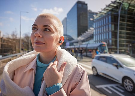 Ženska uživa zunaj s pravimi brezžičnimi slu&scaron;alkami Philips T3508